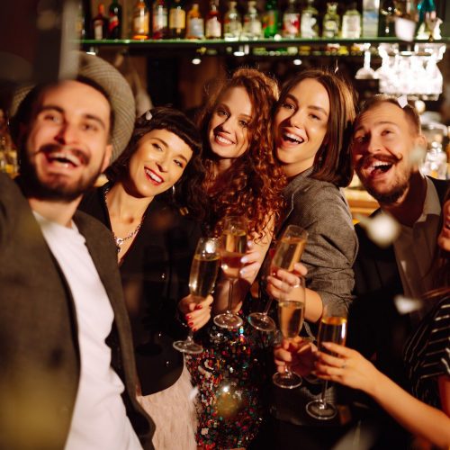 Happy friends throwing confetti and jumping while enjoying party Confetti is fun. Party, celebration